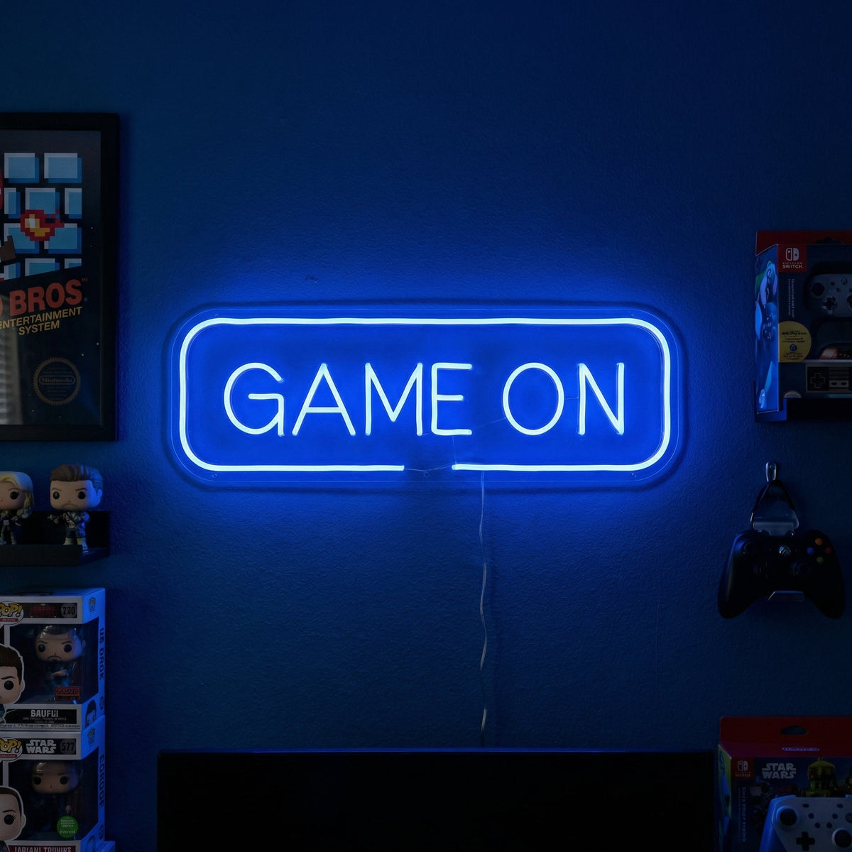 Insegna al neon LED blu GAME ON sopra doppio monitor in sala giochi