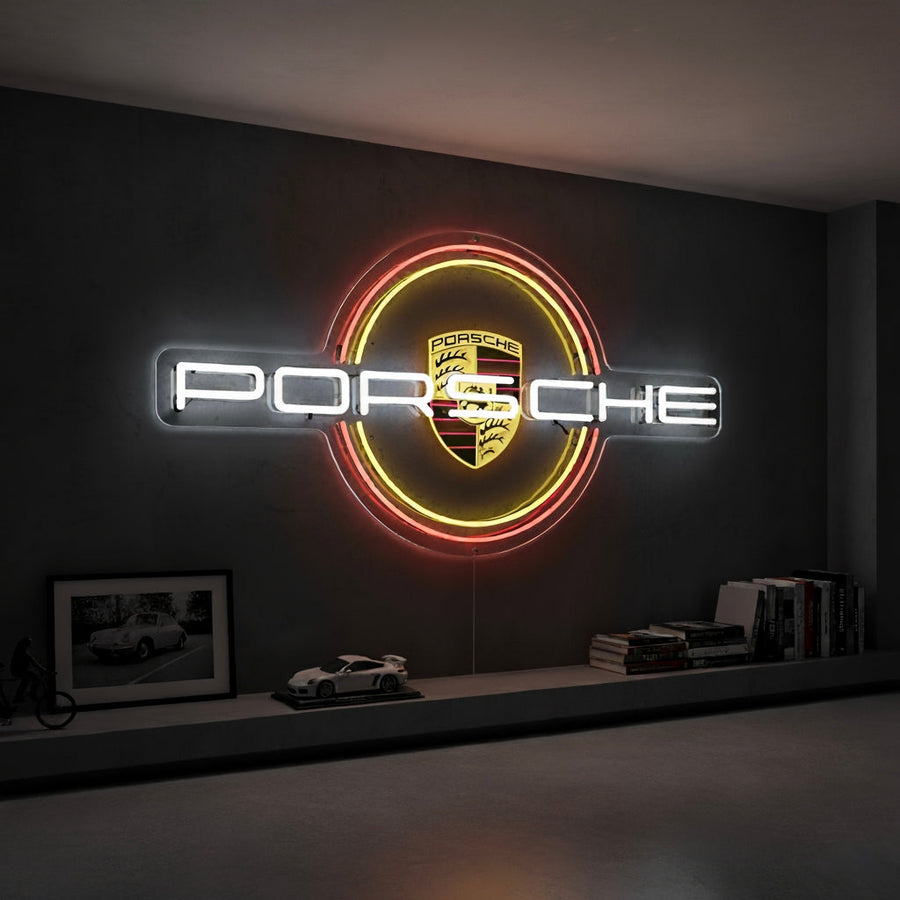 Neon sign with Porsche crest inside a glowing red and yellow circle, with white “Porsche” text.