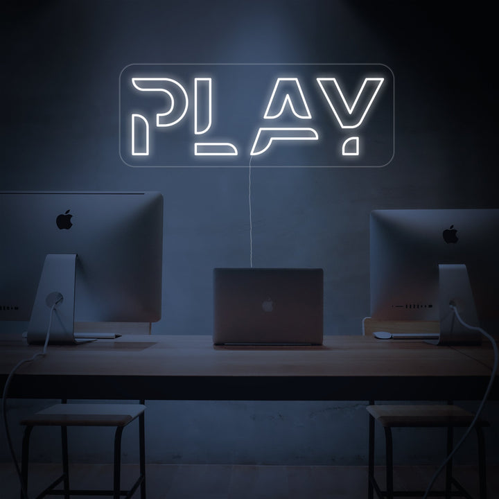 Insegna al neon LED bianca con la scritta PLAY sopra una postazione PC